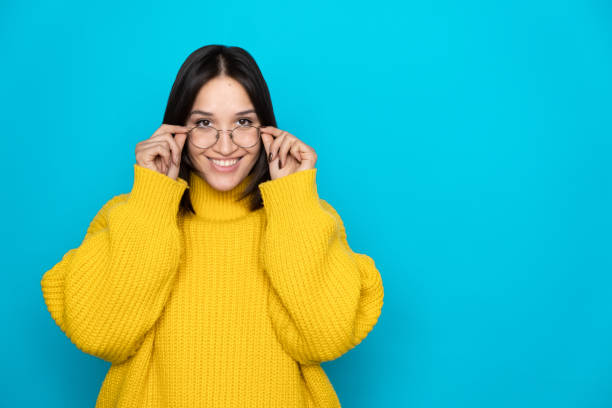 istock Pretty young woman wearing eyeglasses on blue background with space for text 1733205919
