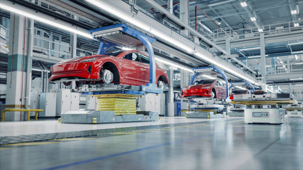 istock EV Production Line on Advanced Automated Smart Factory. High Performance Electric Car Manufacturing. Car Batteries being Attached to Electric Vehicles on Assembly line. AGV Transport Batteries. 1733213113
