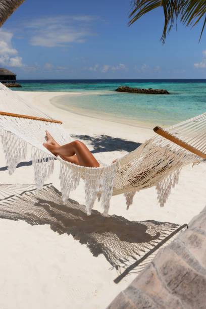 istock Unrecognizable woman relaxing in hammock on the beach. 1733228911