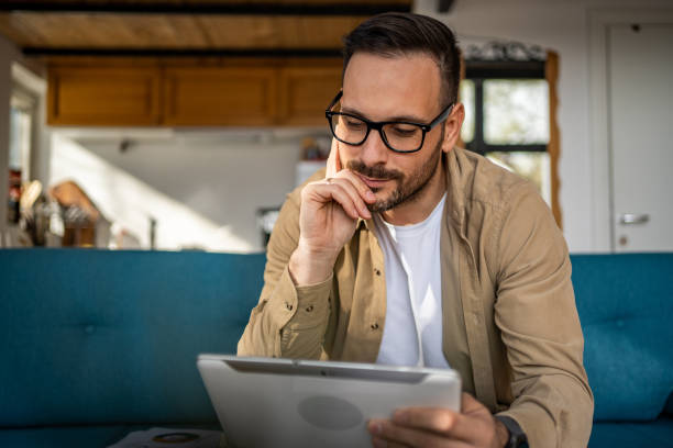 istock Portrait of cheerful man using tablet while sitting in bed in his cozy cottage, copy space 1733254826