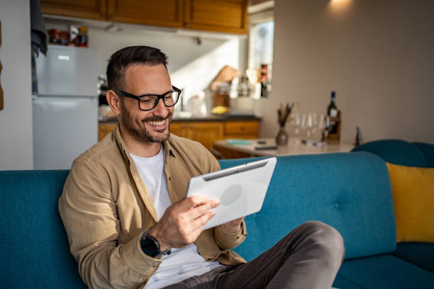 istock Portrait of cheerful man using tablet while sitting in bed in his cozy cottage, copy space 1733254927
