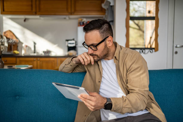 istock Portrait of cheerful man using tablet while sitting in bed in his cozy cottage, copy space 1733255221