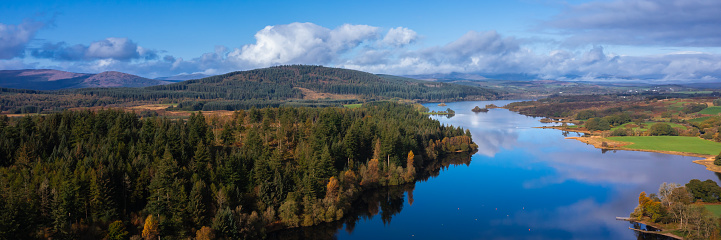 Panoramic aerial view from a drone of a loch in rural Scotland on an autumn morning