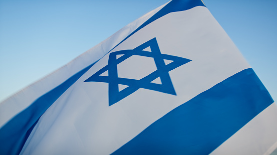 Flag of Israel on blue sky.