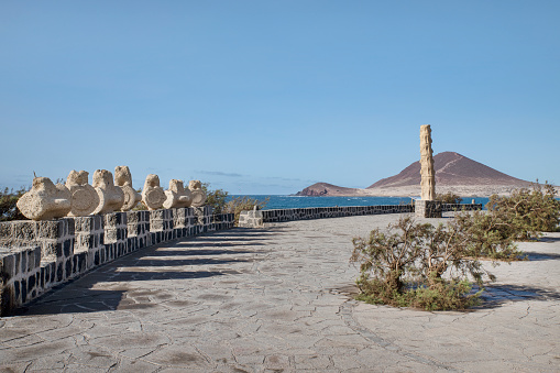 El Medano, Tenerife, Canary Islands, Spain - August 21, 2020: interesting sandstone sculpture facing the ocean, known as Vertebracion y Desvertebracion, a representation of human spine and vertebrae.