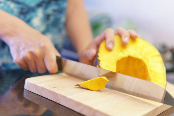 istock Woman hands cutting fresh yellow pumpkin in a kitchen 1733318760