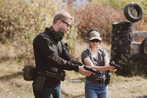 A girl learns to shoot a pistol at a shooting range with an instructor