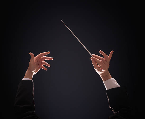 conducting buttons Concert conductor hands with baton over dark background musical conductor photos stock pictures, royalty-free photos & images