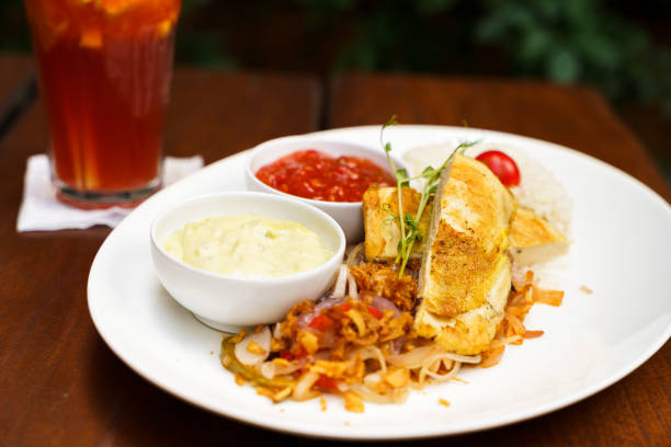 istock Grilled chicken breast with rice, fried onion, salsa and avocado sauce with a lemonade 1733366078