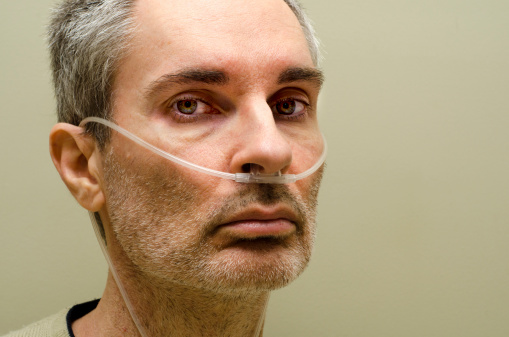 Portrait of middle aged man using medical oxygen.