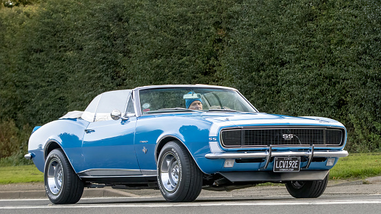 Bicester,Oxon.,UK - Oct 8th 2023: 1967 blue Chevrolet Camaro American  classic car driving on an English country road.
