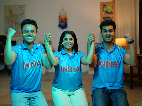 Young siblings with their faces painted with Indian flags - cheering for Indian team, sports fans, cricket