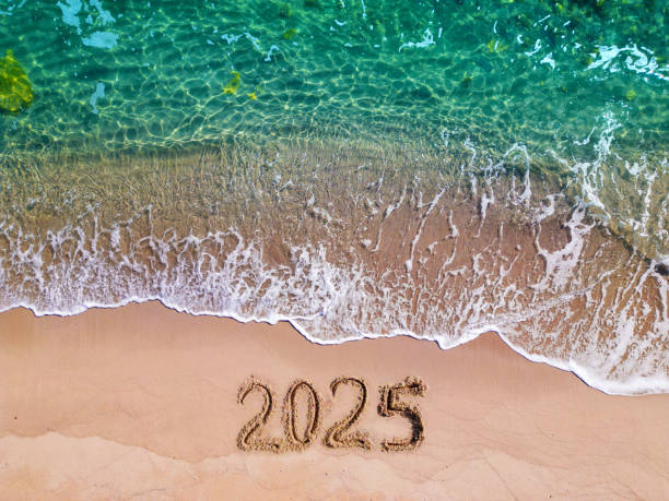 istock 2025 year written on sandy beach sea at sunny day 1733499616