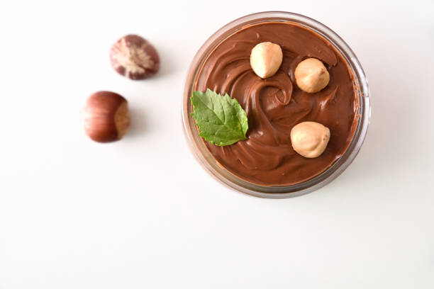istock Cocoa cream with hazelnuts in a glass bowl isolated  white 1733513488
