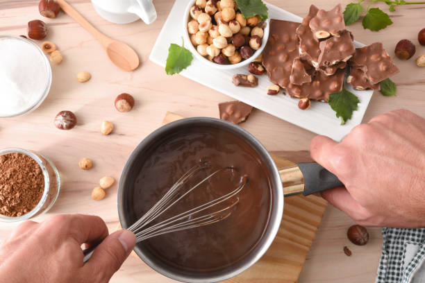selbstgemachte haselnussschokolade auf der küchenbank mit zutaten zubereiten - hot chocolate hot drink high section color image stock-fotos und bilder