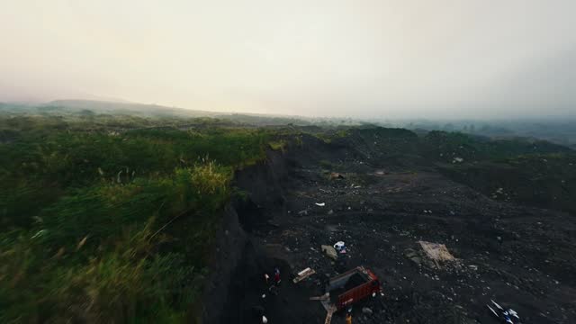 Fpv sport drone flying over mountains green valley with black frozen lava magma