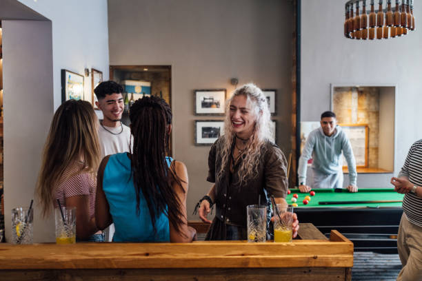 Group of happy friends enjoying beer, crisps and talks in the evening pub