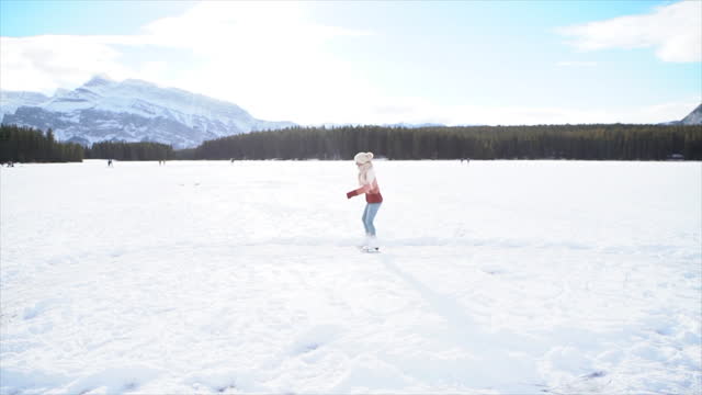 Slow Motion: Woman iceskating outdoors on winter vacation