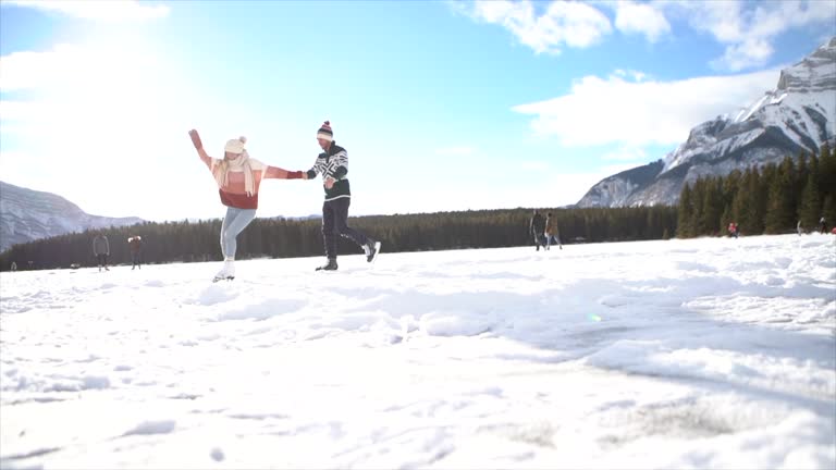 Slow Motion: Couple iceskating on frozen lake