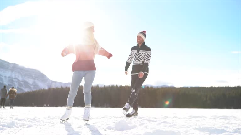 Slow Motion: Couple iceskating on frozen lake