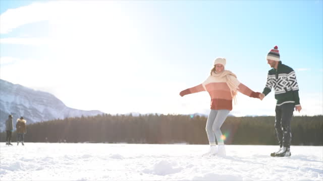 Slow Motion: Couple iceskating on frozen lake