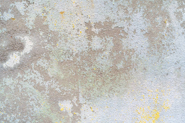 flaking yellow white paint on the stucco exterior wall of an old house - building exterior obsolete abandoned damaged imagens e fotografias de stock