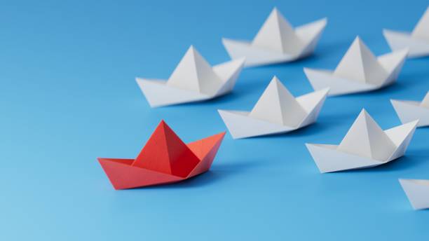 istock Different business concept.new ideas. paper art style. creative idea.Leadership concept with red paper ship leading among white.3D rendering on blue background. 1733609920