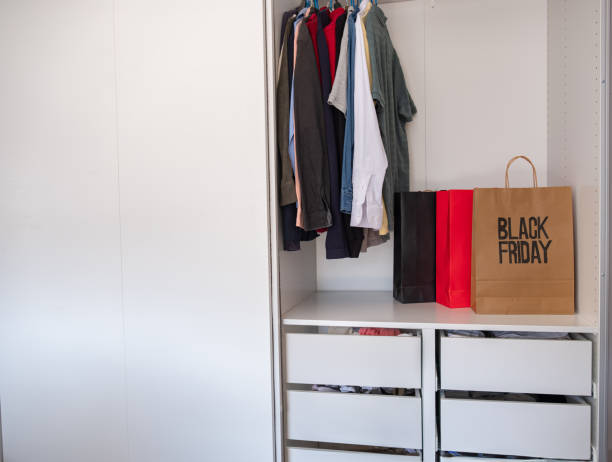 istock Black friday shopping bag with clothes with clothes hanger inside wardrobe , also with mock up space 1733629753