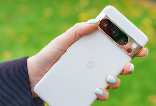 Glasgow, Scotland - A woman holding a Google Pixel 8 Pro smartphone, showing the cameras and other sensors on the rear of the phone.