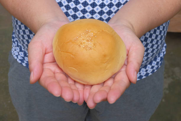 Female hand holding a testy bun , bakery food.