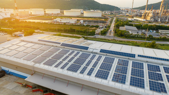 Top view Solar Panels on Warehouse Factory. Solar photo voltaic panels system power or Solar Cell on industrial building roof for producing green ecological electricity. Production of renewable energy.