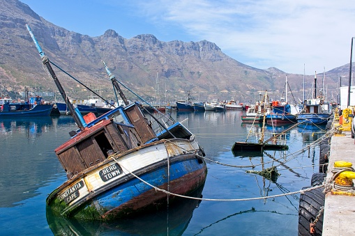 Hout Bay, South Africa - March 14, 2017 : Half sunken Fishing boat in the Hout Bay harbor