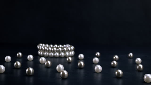 White and gray pearls on black background