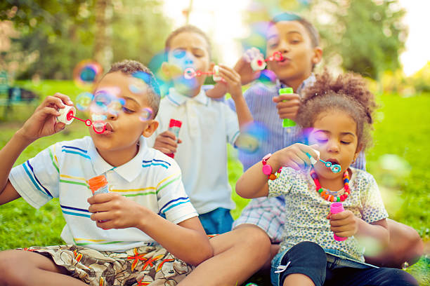 crianças soprando bolhas de sabão - bubble wand bubble child playful - fotografias e filmes do acervo