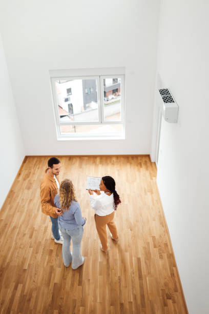 istock Real estate agent talking with couple in new empty apartment 1733700051