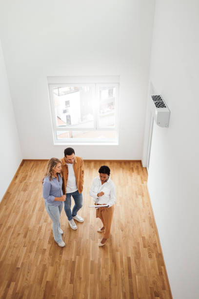 istock Real estate agent talking with couple in new empty apartment 1733700055