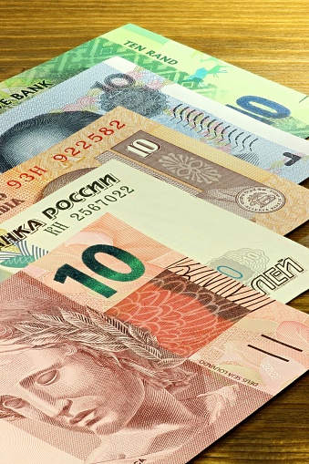 banknotes of the BRICS states on wooden background