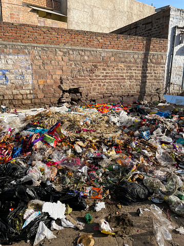 Jodhpur, India - April 13, 2023: Stock photo showing close-up view of residential street area littered with debris and turned into a rubbish dump due to India's booming population.