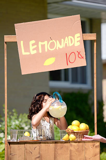 menina beber limonada de um lançador - retro revival lemonade stand old fashioned lemonade imagens e fotografias de stock