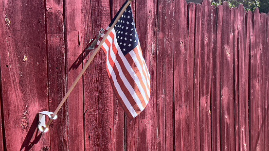 Little flag on a red fence
