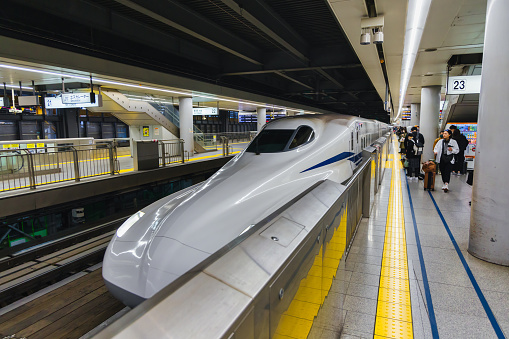 Tokyo, Japan  April 13, 2023: Shinkansen train at a railway station in Tokyo, with unidentified people. The Shinkansen is a network of high-speed railway lines in Japan