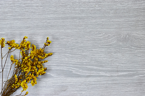 Yellow  baby's breath, gypsophila dry flowers on wooden table. flat lay, top view, copy space