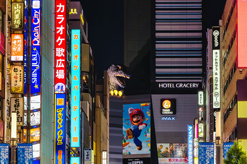 Tokyo, Japan - April 09, 2023: Godzilla sculpture on a building  of Kabukicho, Shinjuku, Tokyo, at night. Kabukicho is an entertainment district in Shinjuku. The famous Kabukicho area has many movie theaters