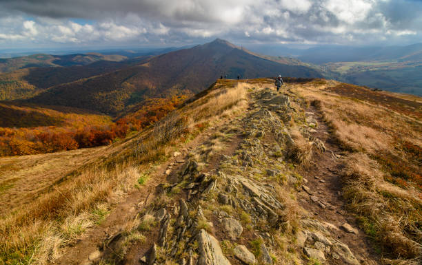 Autumn in the mountains, Bieszczady. Poland. Tourist hiking trail Tourist on the trail in the mountains. Autumn in the mountains. Meadows and mountains. Gold colored grassland. View from Wetlinska Polonina to Carynska Polonina. bieszczady mountains stock pictures, royalty-free photos & images