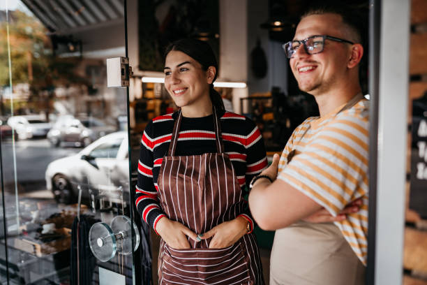 istock Two young Cobblers looking away in front of their shoe store 1733803607