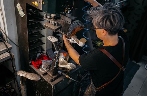 Mature Female Shoemaker making Shoe Pads