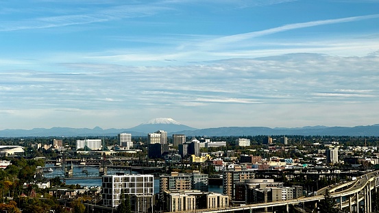 A snowcapped Mount St. Helens rises above the Portland city center with the Willamette River also visible.