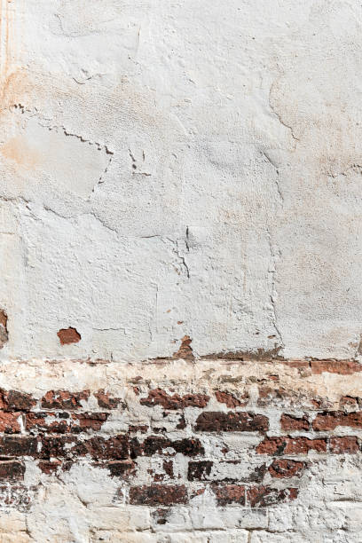 istock Textured concrete cracked white wall background with brick 1733902074