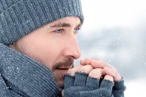 Handsome guy with blue eyes outdoors. Winter portrait.