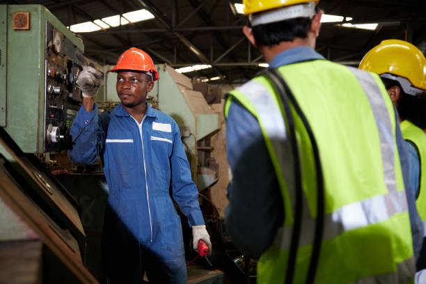 istock male african foreman training and teaching how to use machine control with workers in factory 1733914511